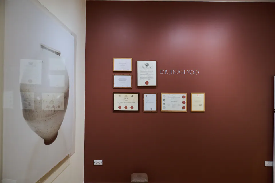 Dr Yoo's framed qualifications on the clinic wall