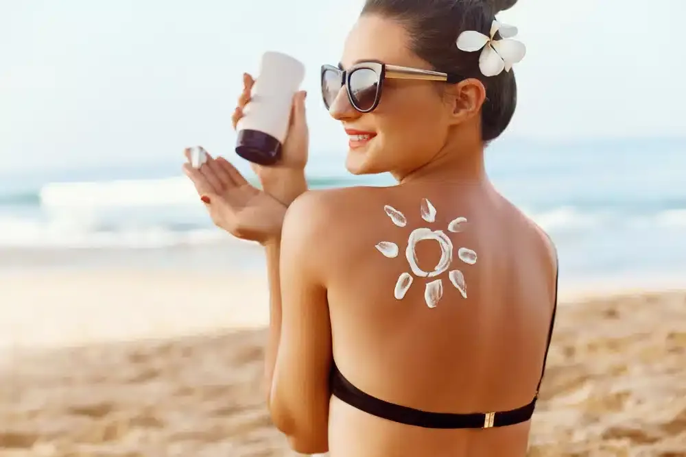 woman applying suncream to prevent pigmentation from sun exposure