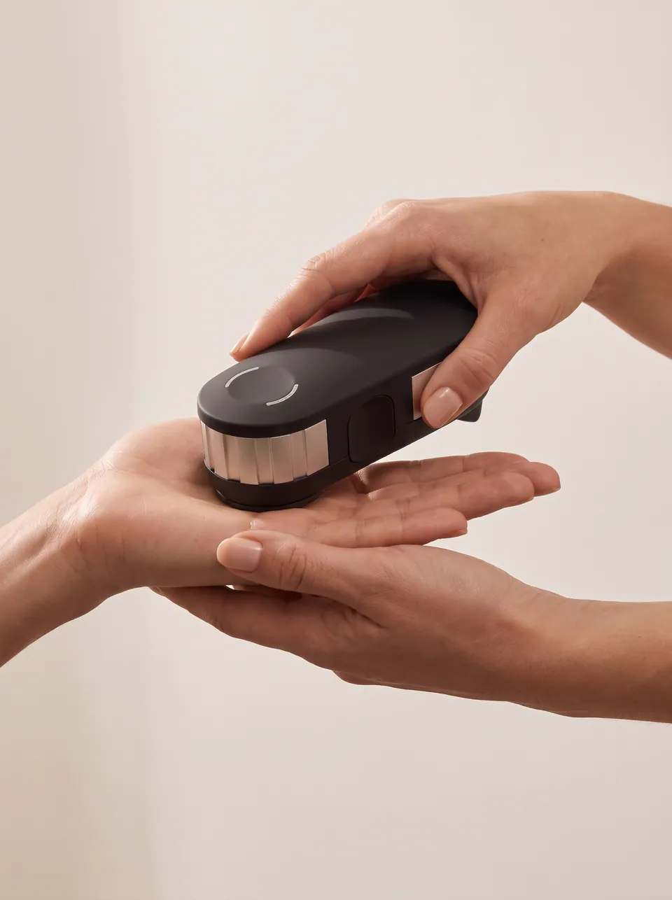 The OligoScan handheld spectrophotometer held against a patient's palm