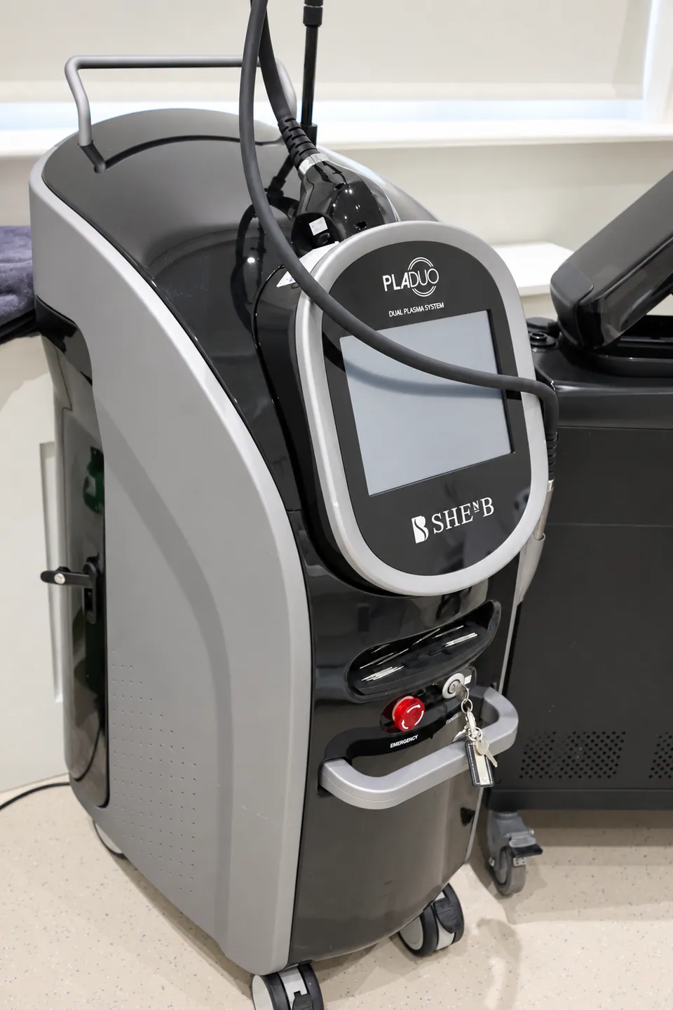 The Pladuo dual plasma system in the treatment room, handpiece resting on its console