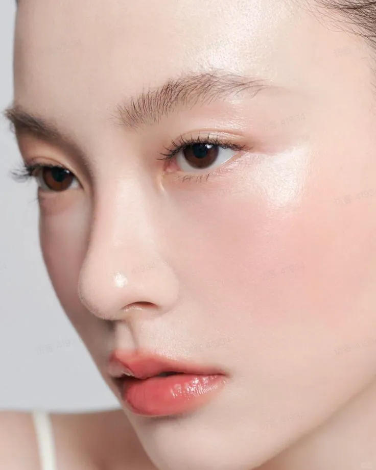 Portrait of a woman with calm, dewy skin and a natural flush