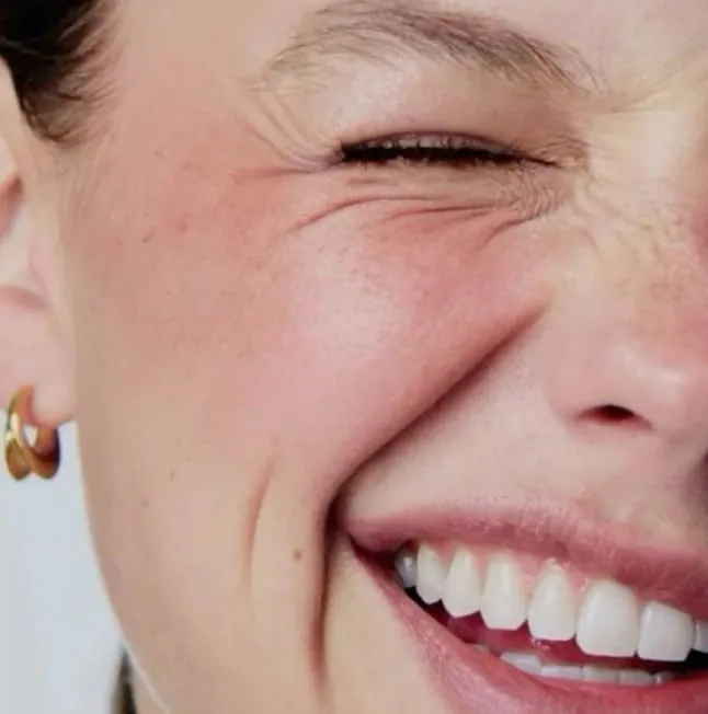 A smiling woman with laughter lines around her eyes