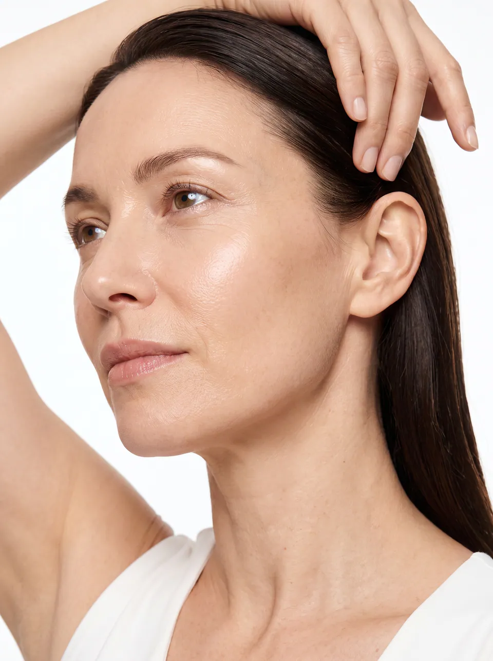 A woman with her hair swept back, showing a lifted jawline and radiant skin