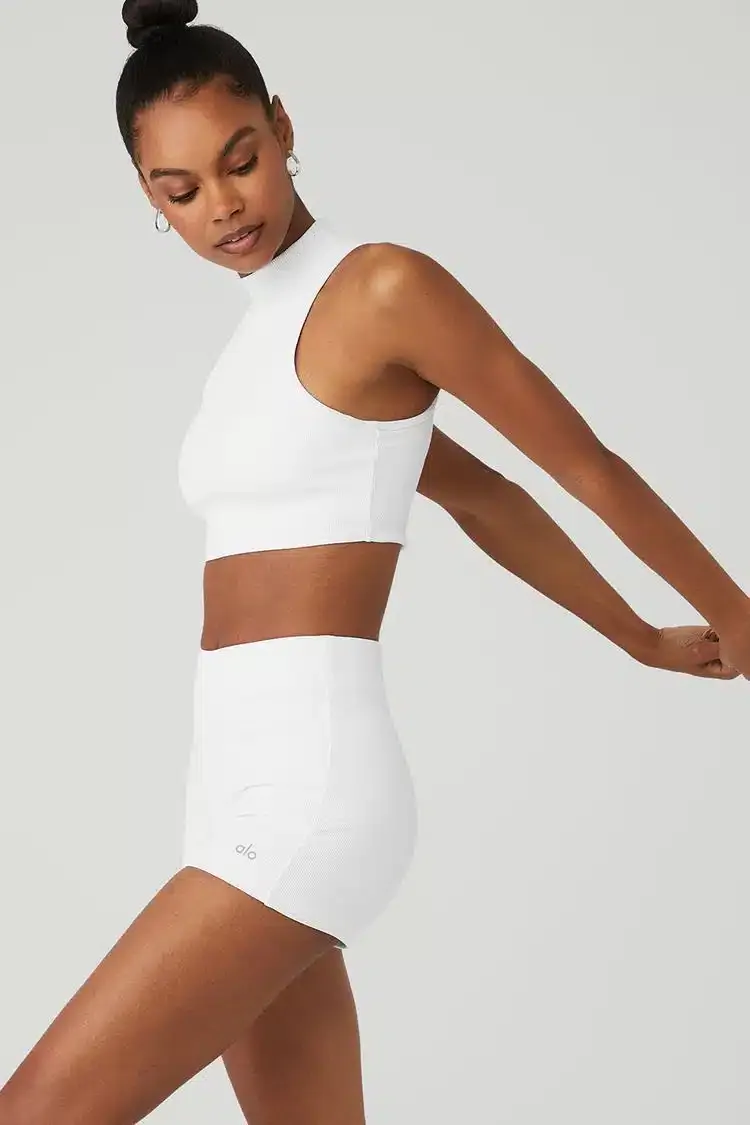 A woman in white activewear stretching